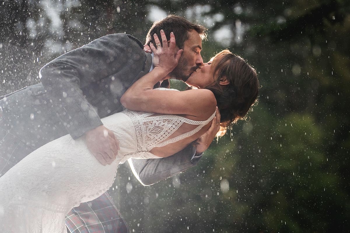 A photo of a wedding couple in the rain at Aberdeenshire venue Glen Tannor taken by wedding photographer Jonathan Addie
